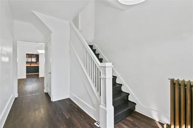 a view of a hallway with wooden floor and entryway