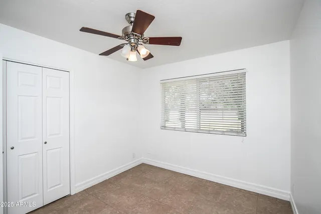 a view of a room with a ceiling fan and a window
