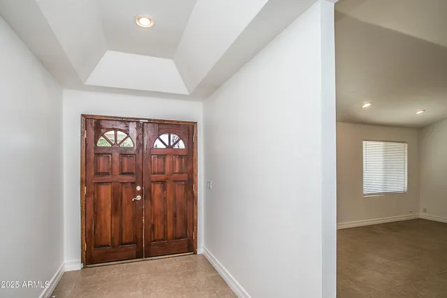 an entryway with wooden floor and cabinet
