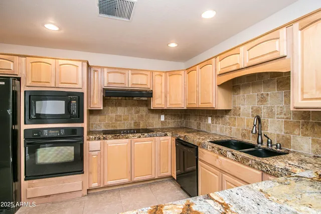 a kitchen with stainless steel appliances granite countertop a sink stove and microwave