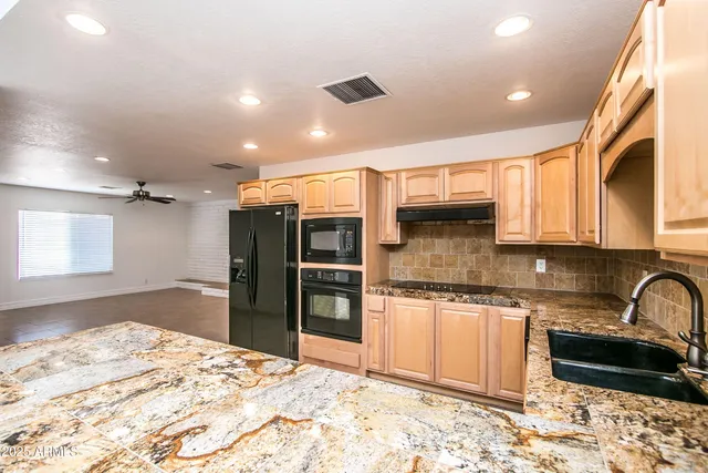 a kitchen with stainless steel appliances granite countertop a refrigerator and a sink