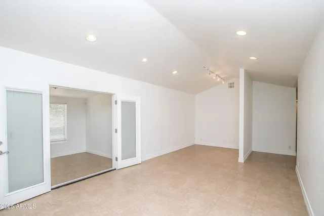 an empty room with closet and windows