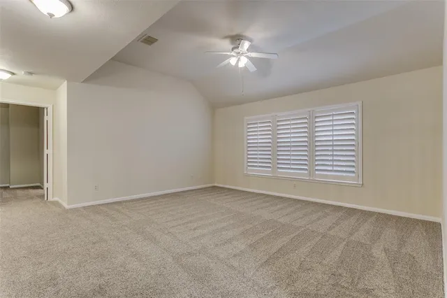 a view of an empty room with a chandelier fan