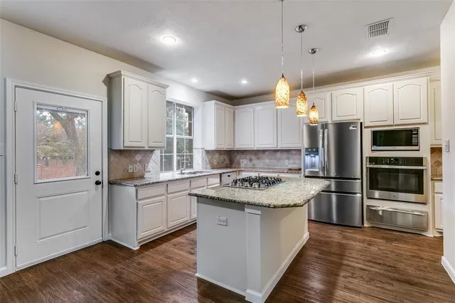 a kitchen with a refrigerator and a stove top oven