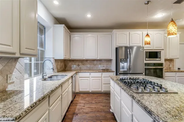 a kitchen with stainless steel appliances granite countertop a sink stove and refrigerator