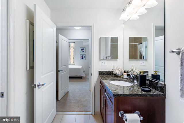 a bathroom with a granite countertop sink toilet mirror and shower