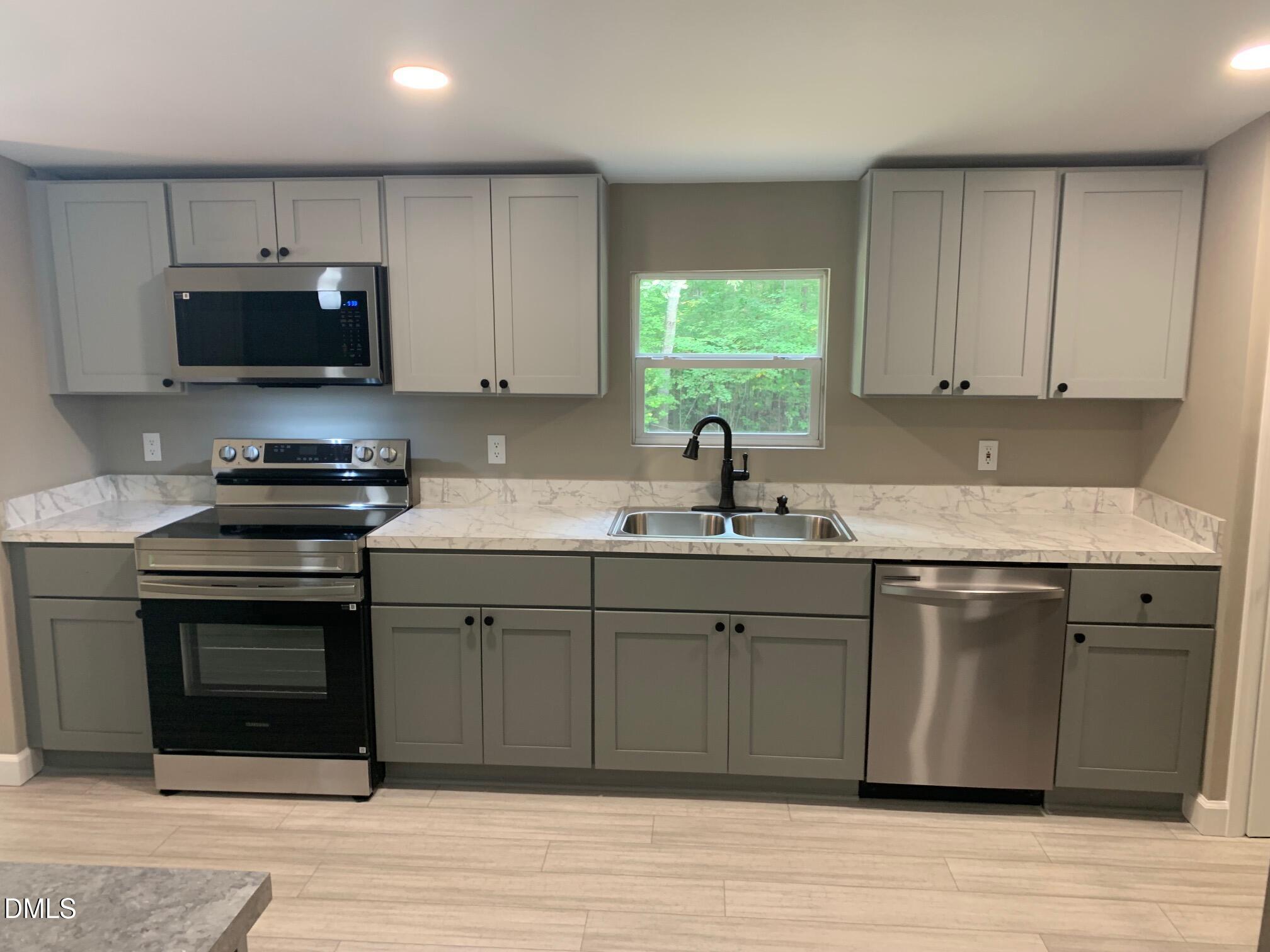 204 Deep Woods Trail Roxboro, NC 27574 - Photo 14 of 28 a kitchen with stainless steel appliances granite countertop a sink stove and microwave