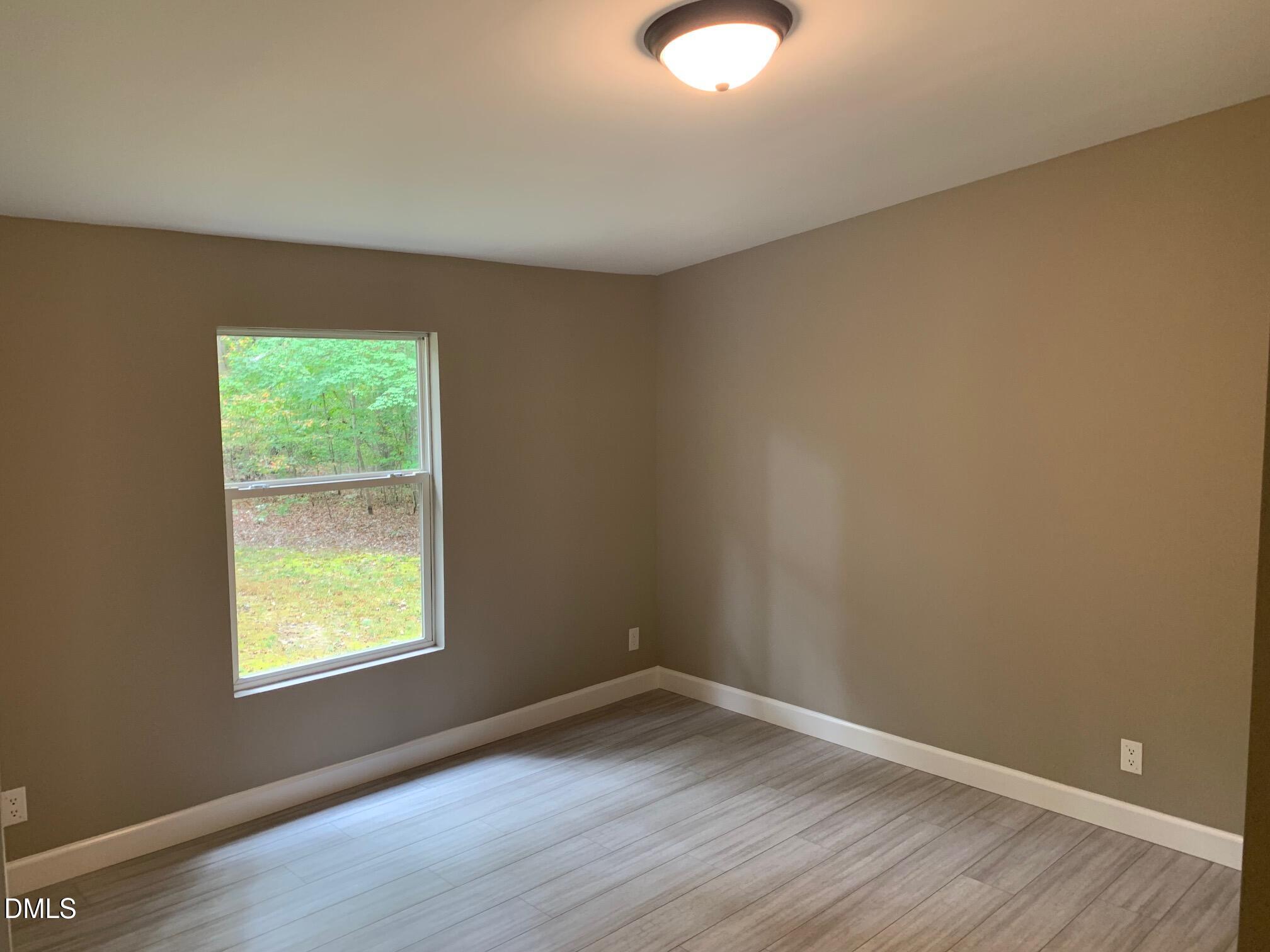 204 Deep Woods Trail Roxboro, NC 27574 - Photo 22 of 28 a view of an empty room with wooden floor and a window