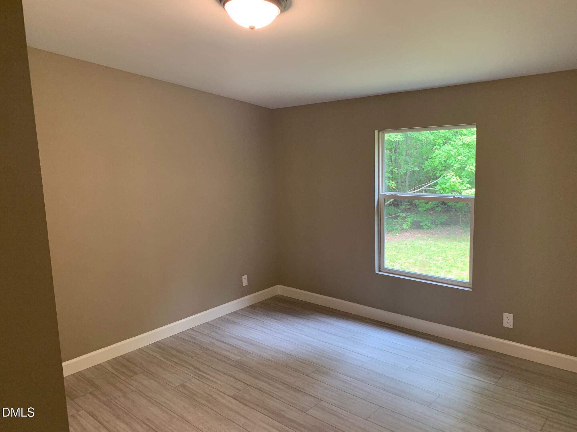 204 Deep Woods Trail Roxboro, NC 27574 - Photo 23 of 28 a view of an empty room with wooden floor and a window