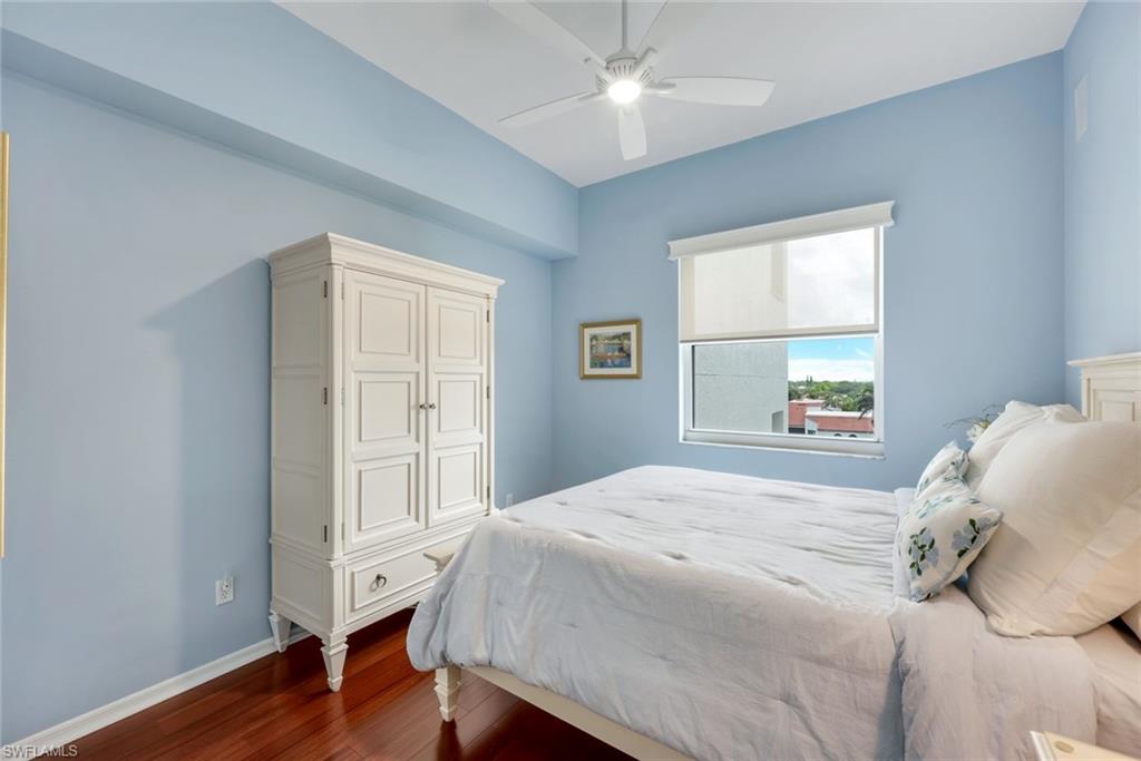 460 Launch Circle, Unit PH1 Naples, FL 34108 - Photo 12 of 28 a bedroom with a large bed window and a chandelier