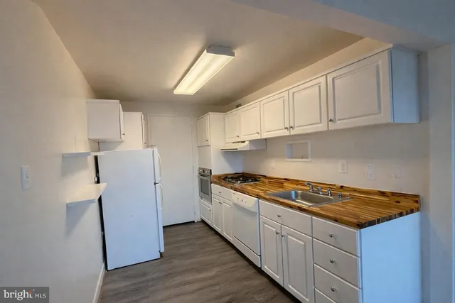 a kitchen with a stove a refrigerator and cabinets
