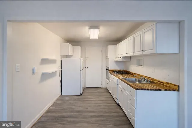 a kitchen with a stove a refrigerator and a sink