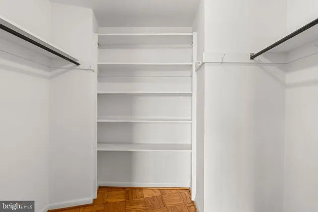 a view of walk in closet with empty racks