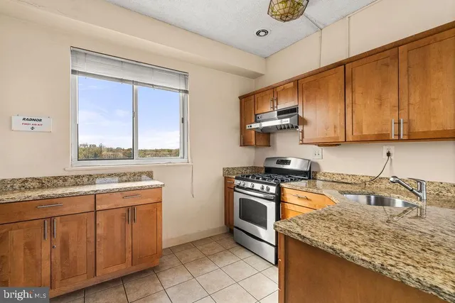 a kitchen with granite countertop cabinets stainless steel appliances and a sink