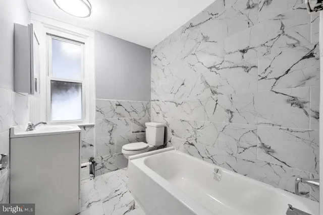a bathroom with a sink toilet mirror and vanity