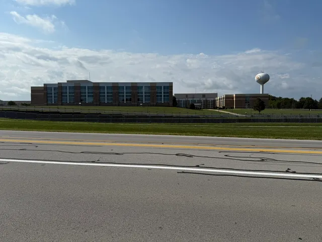 a view of a big house with a big yard and large trees