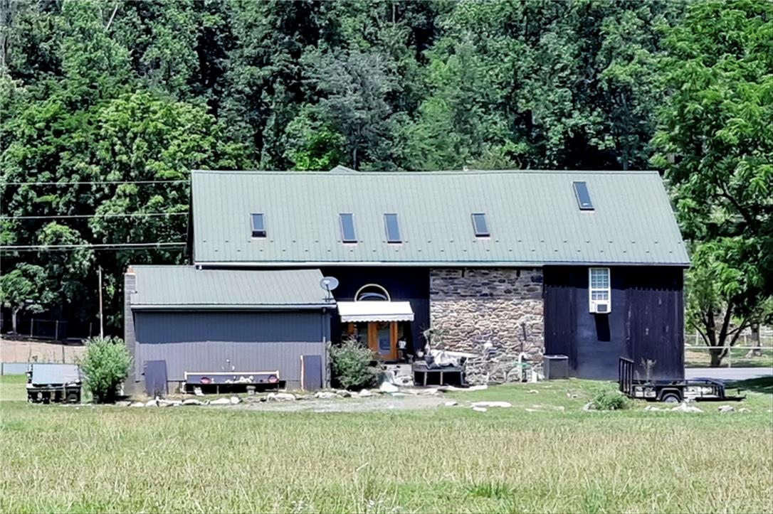 101 Conrad Road Fleetwood, PA 19522 - Photo 33 of 42 A classic barn-style structure, converted for residential use, sits amidst a verdant landscape.