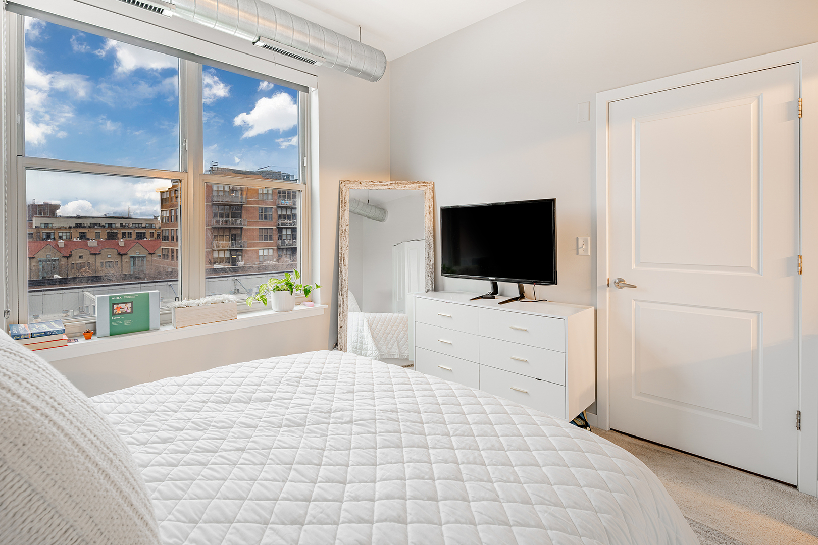 1228 West Monroe Street, Unit 504 Chicago, IL 60607 - Photo 15 of 23 a room with a flat screen tv and a bed