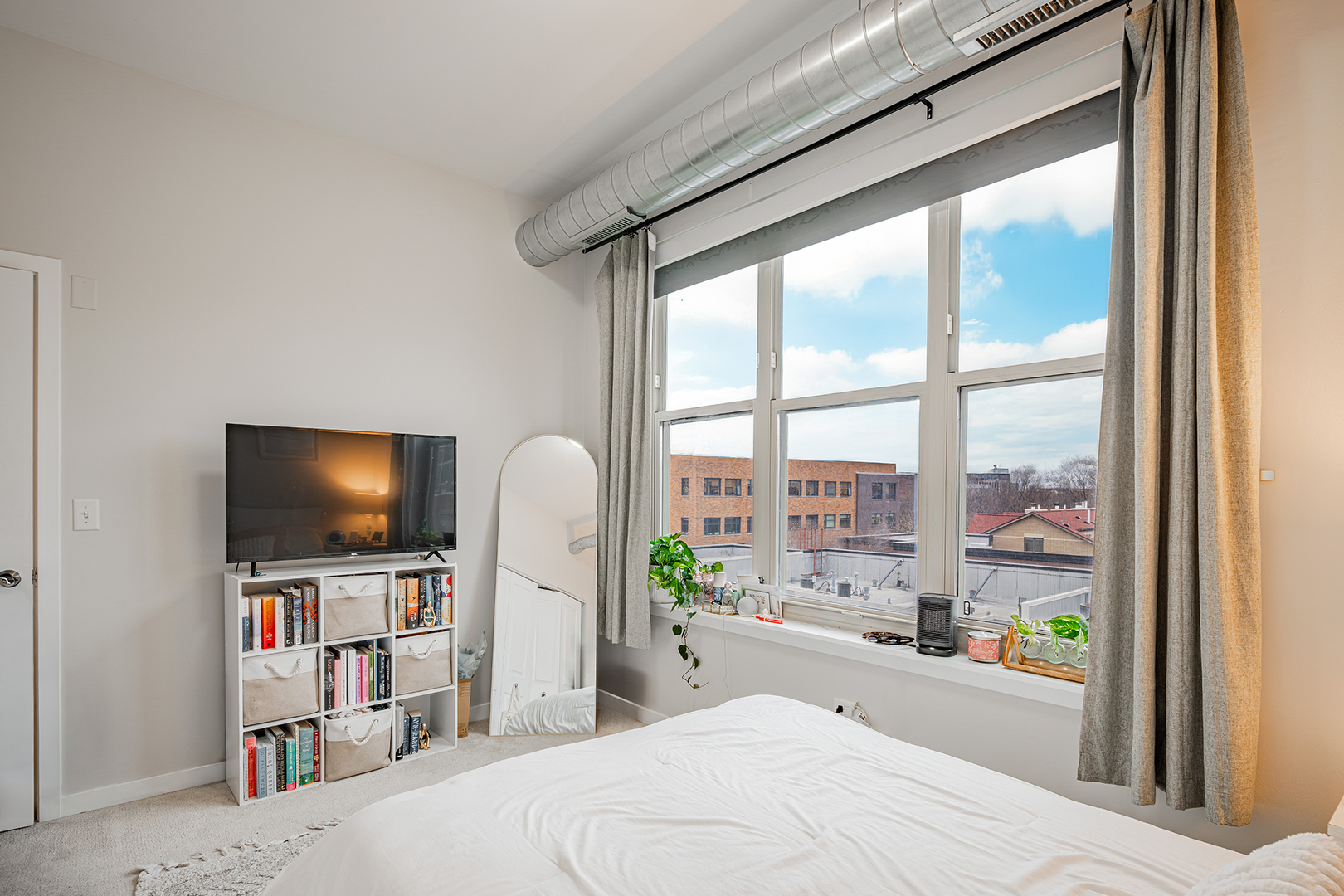 1228 West Monroe Street, Unit 504 Chicago, IL 60607 - Photo 20 of 23 a living room with flat screen tv and a floor to ceiling window