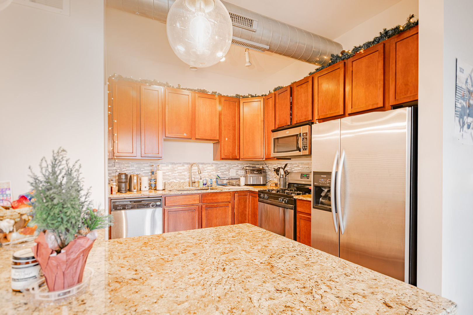 1228 West Monroe Street, Unit 504 Chicago, IL 60607 - Photo 6 of 23 a kitchen with stainless steel appliances kitchen island granite countertop a refrigerator and a stove top oven