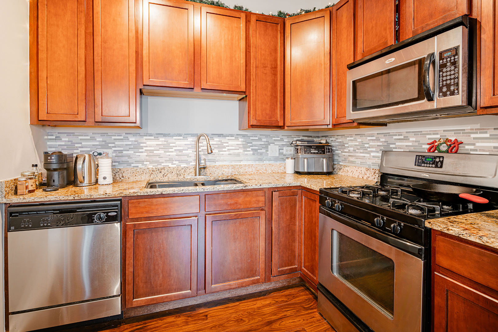 1228 West Monroe Street, Unit 504 Chicago, IL 60607 - Photo 7 of 23 a kitchen with stainless steel appliances granite countertop a stove a sink and dishwasher microwave oven with cabinets