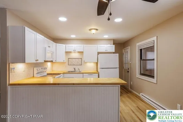 a view of a kitchen with center island and stainless steel appliances