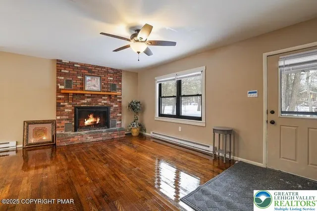 a view of an empty room with window and wooden floor