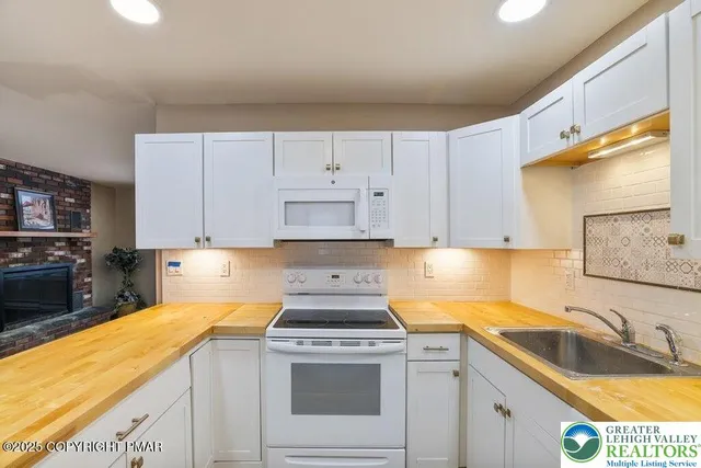 a kitchen with granite countertop a sink a stove and cabinets