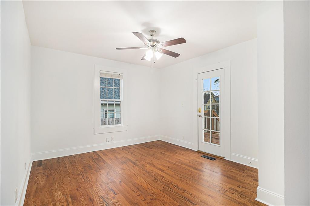 1719 Flat Shoals Road Southeast Atlanta, GA 30316 - Photo 16 of 28 an empty room with wooden floor ceiling fan and windows