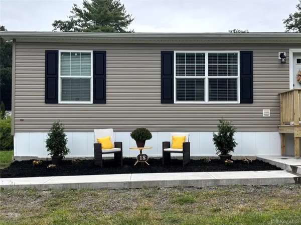 a front view of a house with garden and plants