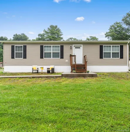 a front view of house with yard seating and green space