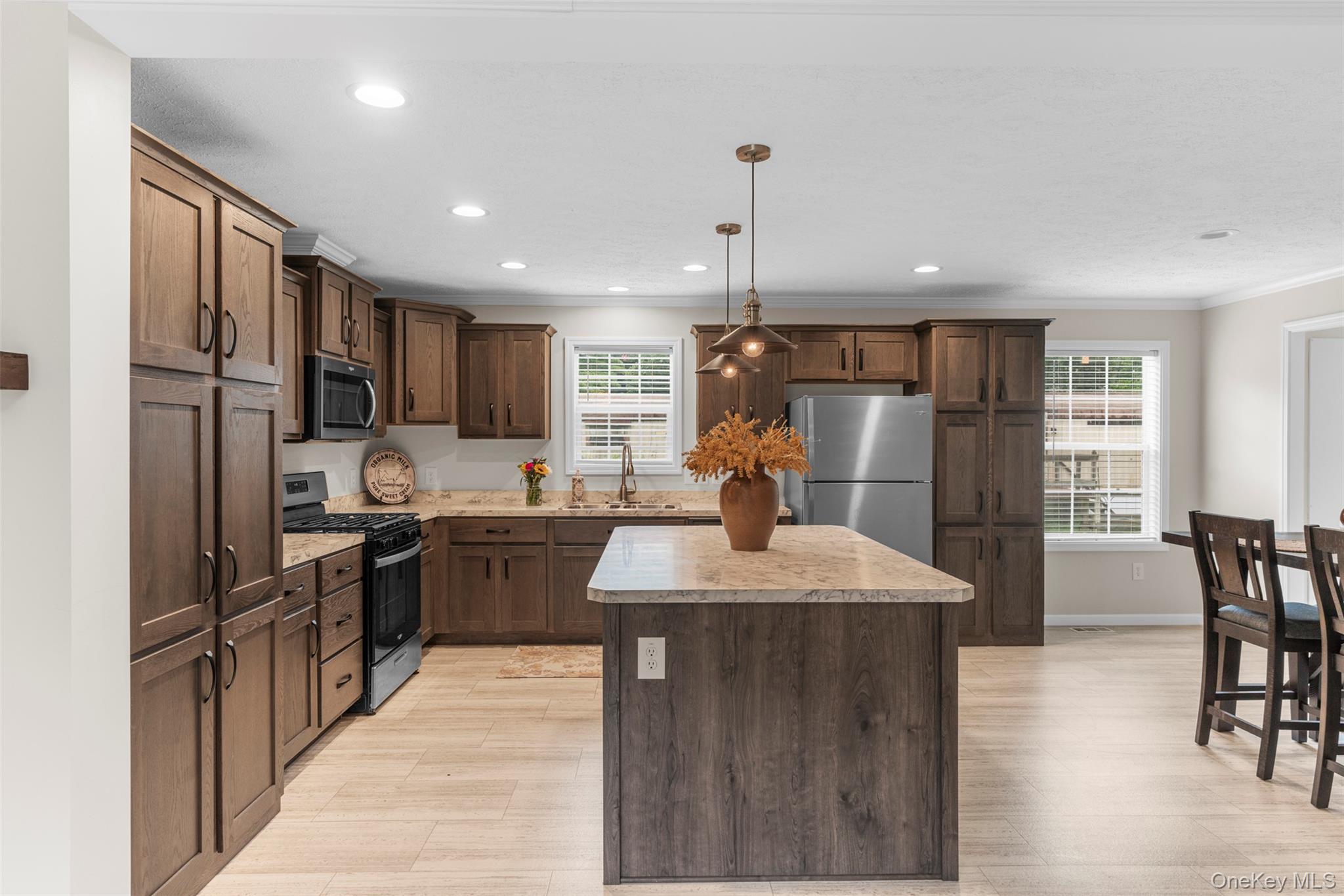 242 Ruby Road, Unit 18 Kingston, NY 12401 - Photo 7 of 23 a kitchen with stainless steel appliances granite countertop a refrigerator a sink dishwasher a stove and a dining table with wooden floor