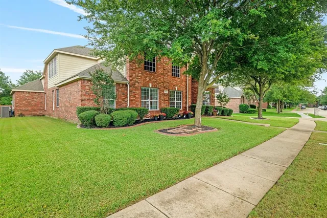 a view of a house with a big yard and large trees