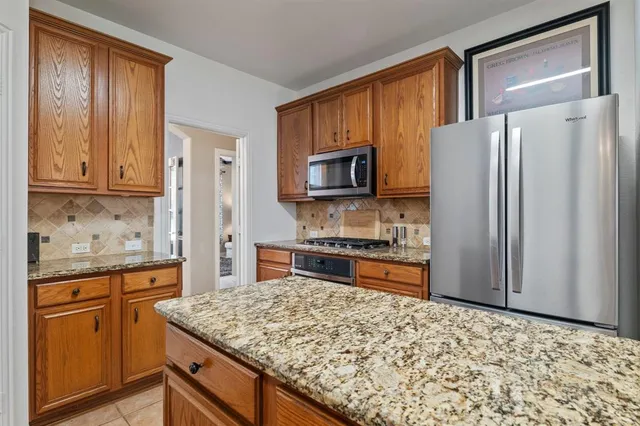 a kitchen with stainless steel appliances granite countertop a refrigerator stove microwave and sink