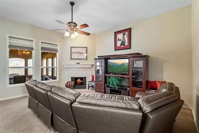 a living room with furniture large window and flat screen tv