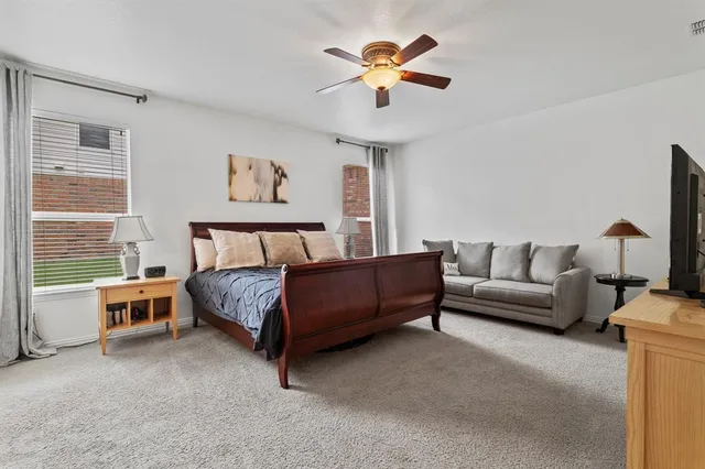 a spacious bedroom with a bed furniture and a window