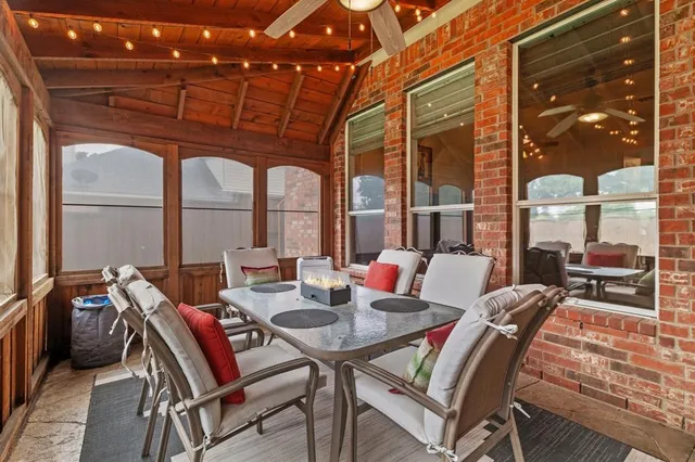 a patio with a table and chairs and potted plants