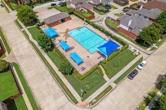 an aerial view of a tennis ground and a cars park