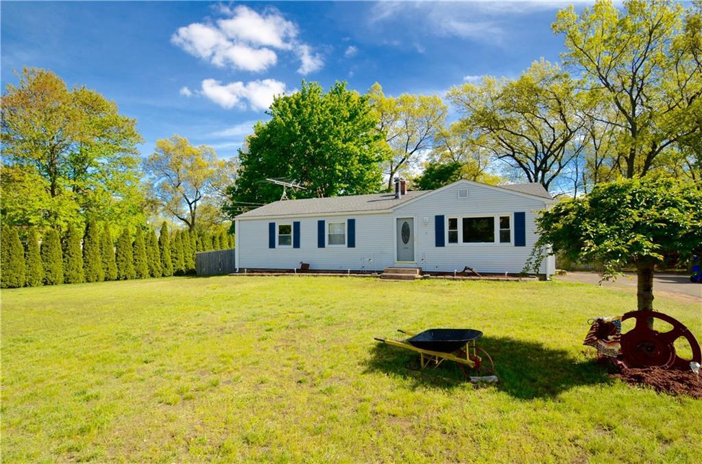 a front view of a house with yard patio and tree