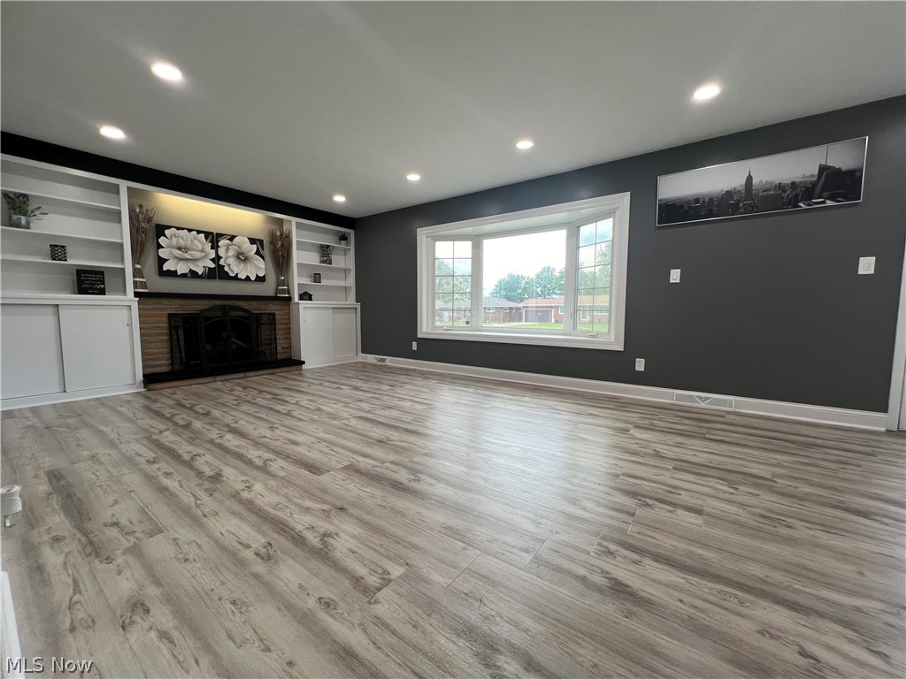 7475 Selwick Drive Parma, OH 44129 - Photo 3 of 29 Unfurnished living room with hardwood / wood-style floors, built in features, and a fireplace