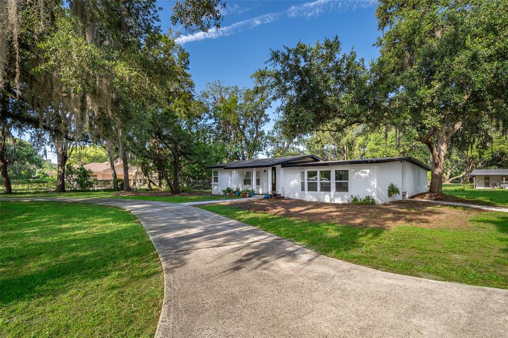 1206 Culver Road Orlando, FL 32825 - Photo 1 of 1 a view of a yard in front of a house with large trees
