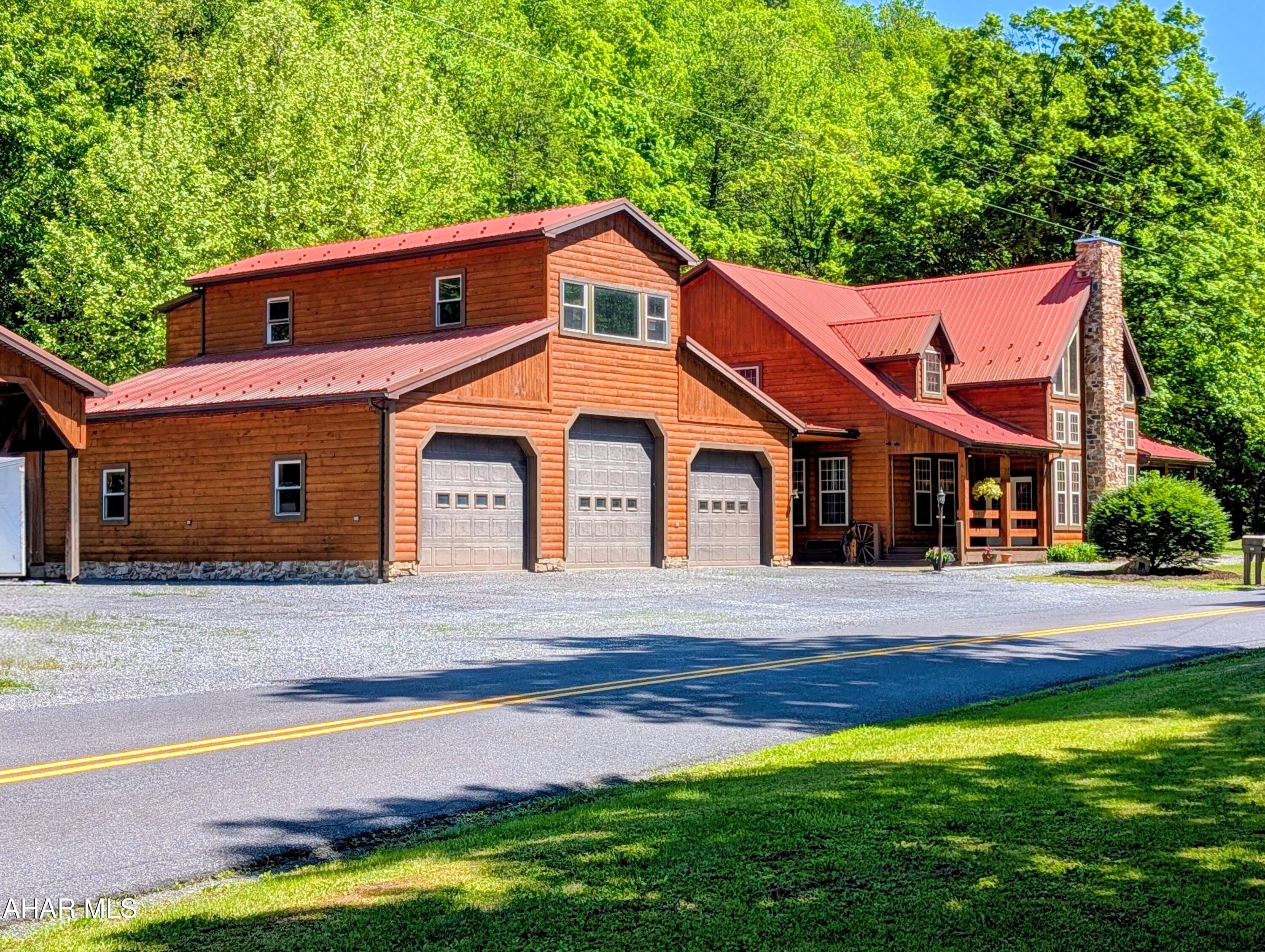 213 Sherman Valley Road Hopewell, PA 16650 - Photo 100 of 104 a front view of a house with a yard and garage