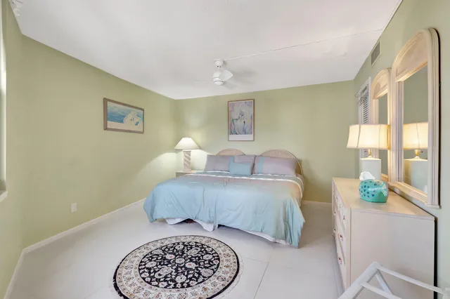 a bedroom with a bed and a large mirror on the dresser