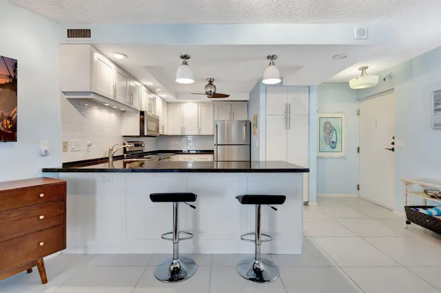 a kitchen with white cabinets and black appliances