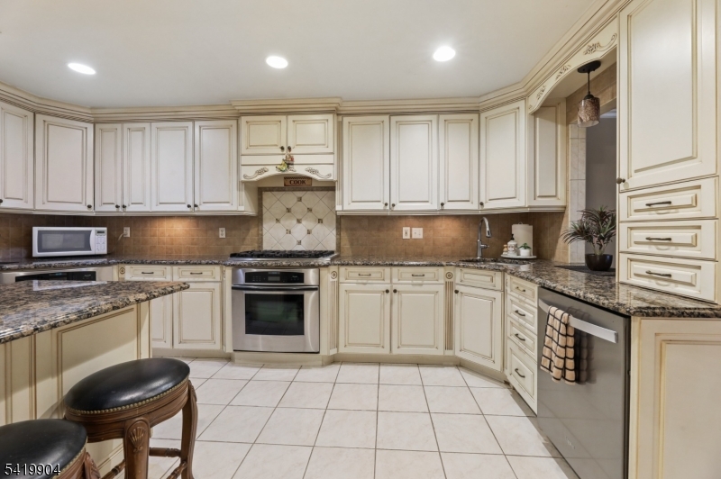 7 Valen Court Franklin Lakes, NJ 07417 - Photo 9 of 32 a kitchen with granite countertop a stove sink and cabinets