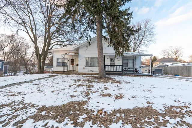 a front view of a house with a yard covered in snow