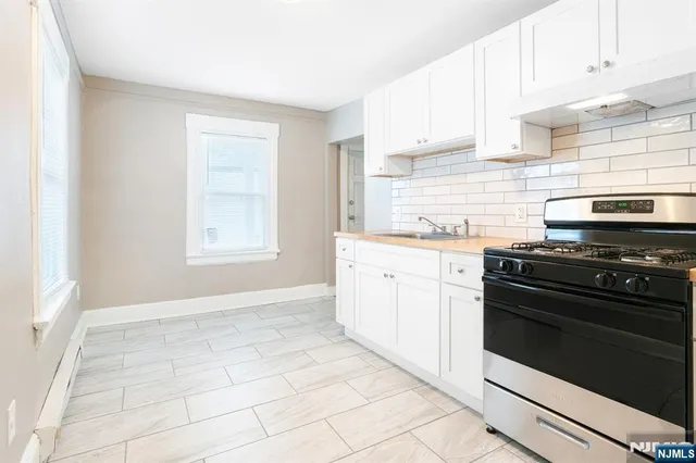 a kitchen with a stove oven and white cabinets