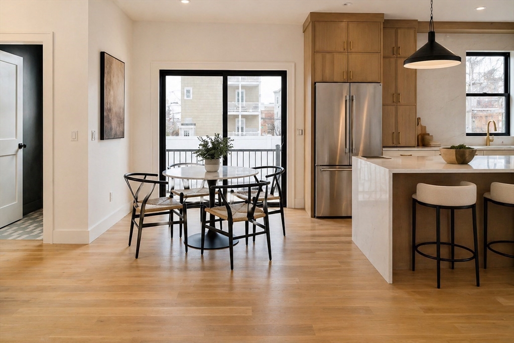 17 South Waverly Street, Unit 17 Boston, MA 02135 - Photo 12 of 29 a dining room with stainless steel appliances granite countertop a dining table chairs refrigerator and sink