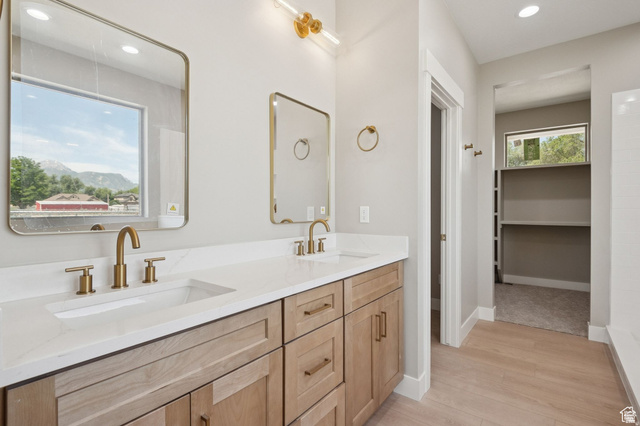 1471 Colbey Loop Santa Clara, UT 84765 - Photo 33 of 45 Primary Bathroom featuring a wood-finish vanity with dual sinks, white quartz countertop, brushed brass fixtures, and framed mirrors with brass accents