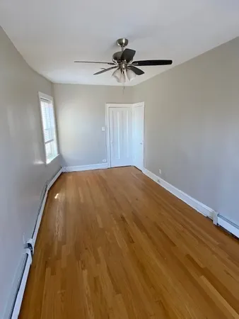 a view of a livingroom with wooden floor and a ceiling fan